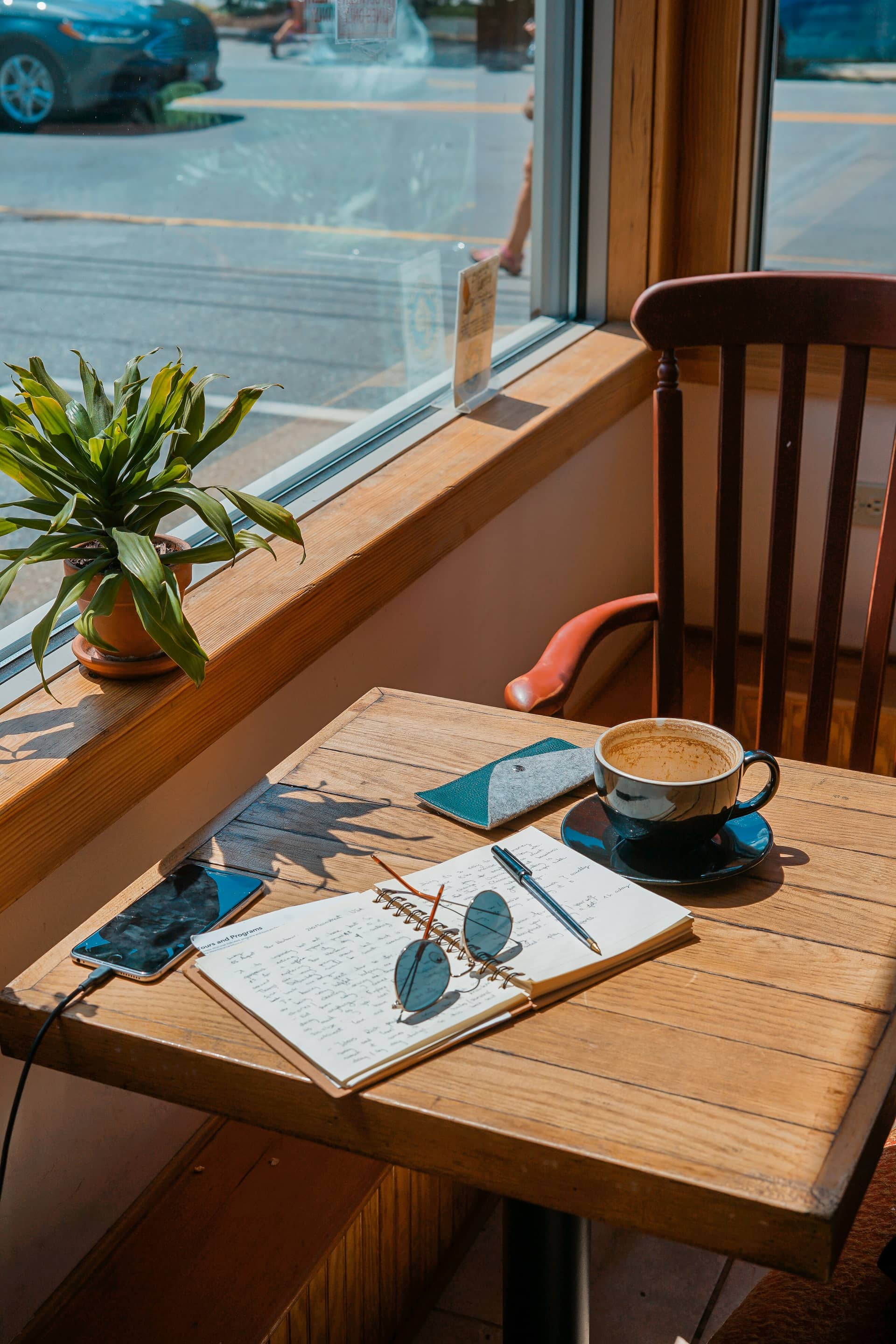 Persona escribiendo en un escritorio soleado